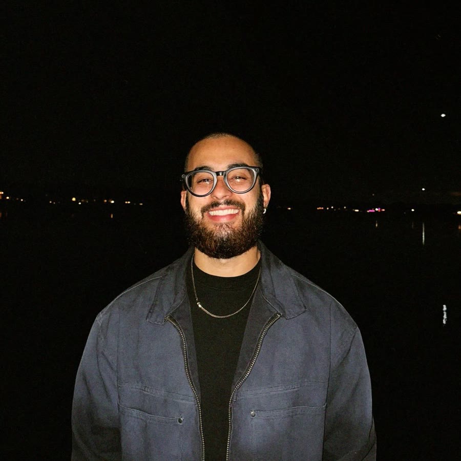 Kelvis Espinoza de noche, con lentes y chaqueta de mezclilla